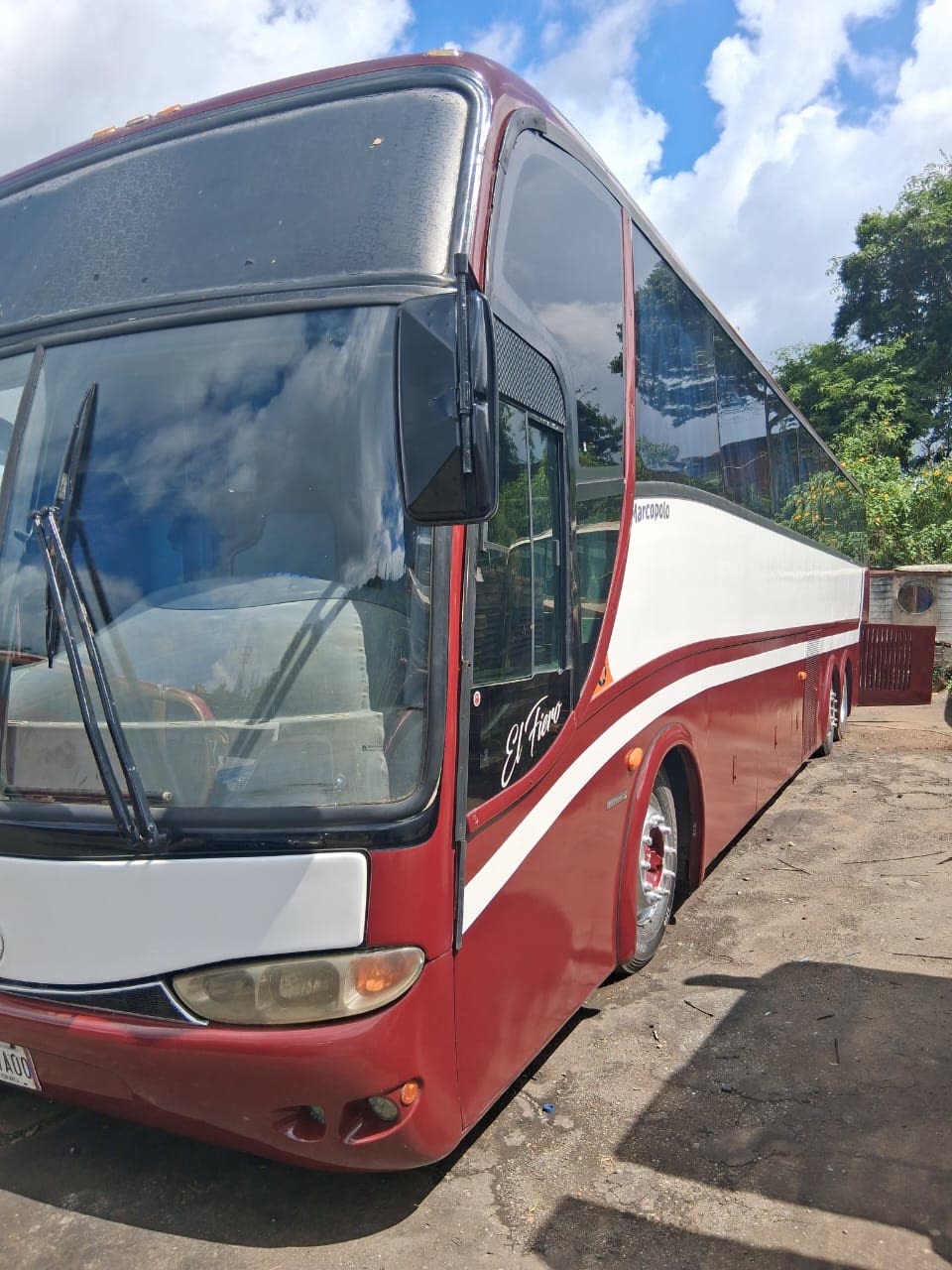 Autobús vinotinto y blanco de ELLOS EXPRESS, carrocería Marcopolo, con el nombre El Fiero en la puerta delantera.